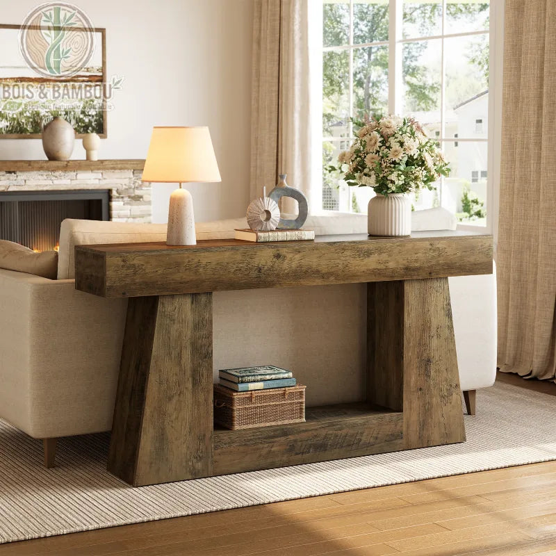 Console allongee style farmhouse 160 cm situation 2. Longue table console en bois massif brut au design robuste, placée derrière un canapé beige et décorée d'une lampe et d'un vase dans un salon chic.