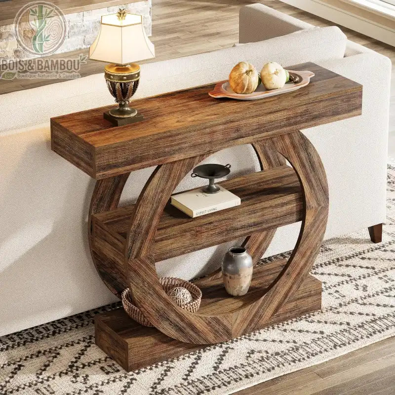 Console en bois massif d entree style farmhouse 3. Table console robuste en bois au design circulaire sculptural, dotée de deux étagères de rangement et placée derrière un canapé dans un salon rustique.