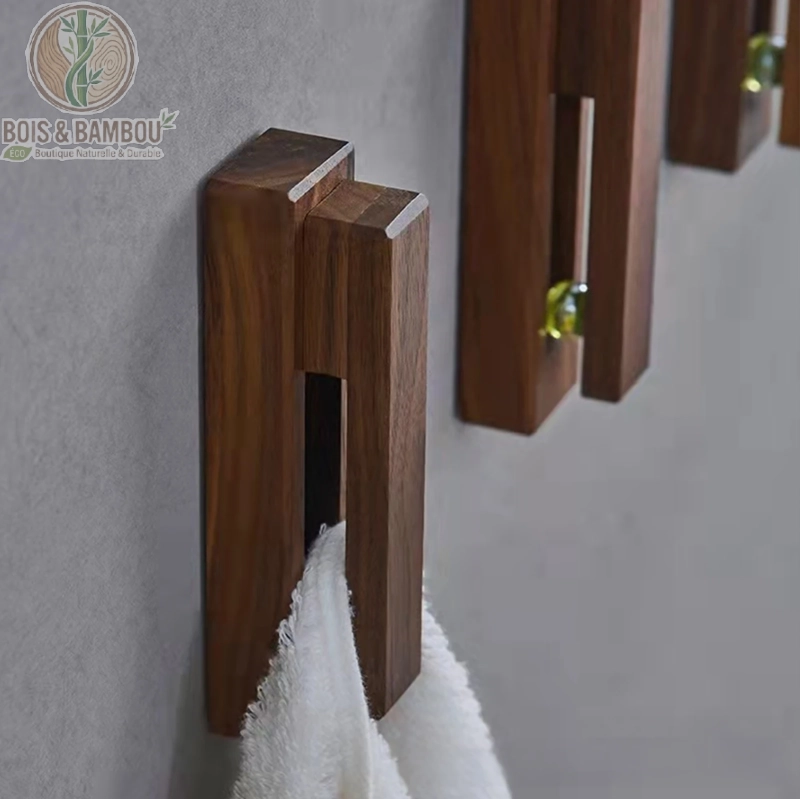 Crochet mural nordique en bois. Porte-serviette design en bois sombre fixé au mur, maintenant une serviette blanche par insertion. Style minimaliste et fonctionnel pour salle de bain.