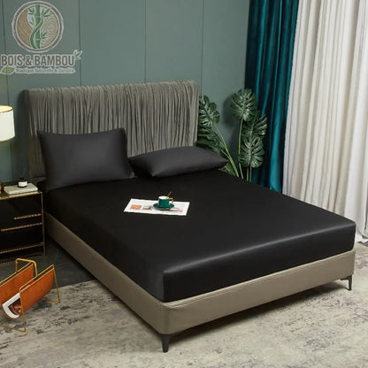 Drap-housse satin bambou noir 160x200 cm en situation sur lit avec oreillers assortis