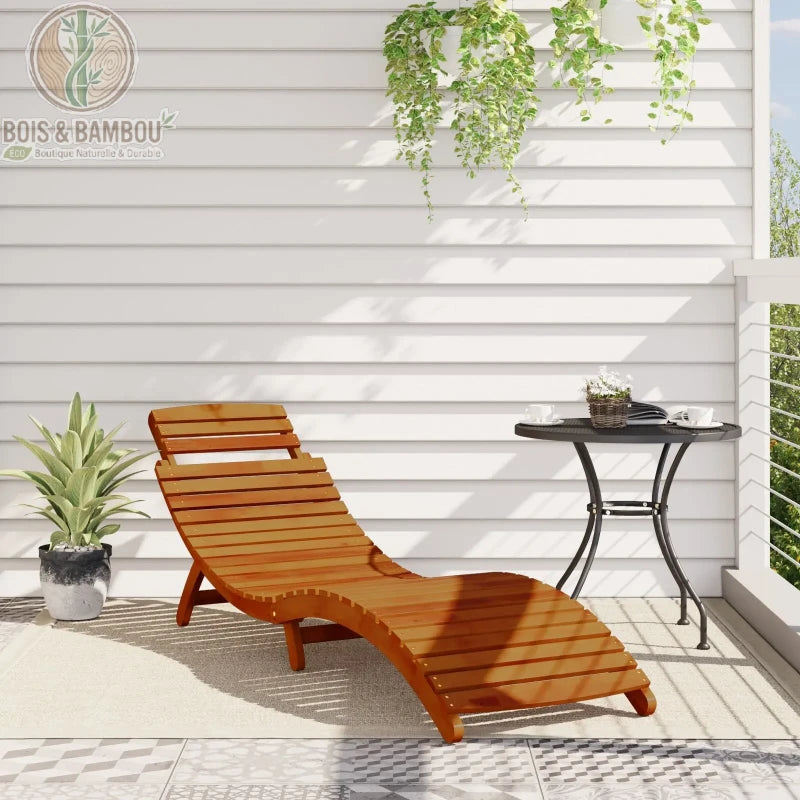 Duo de Chaises Longues en Acacia situation. Mise en situation d'une chaise longue en acacia sur une terrasse ensoleillée à côté d'une petite table noire et d'une plante en pot.