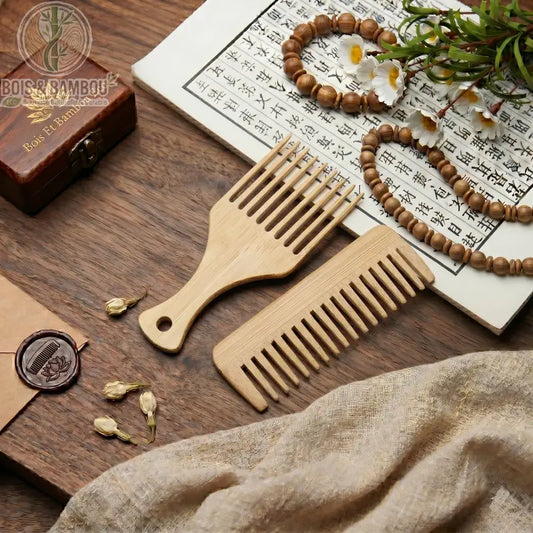 Duo de Peignes en Bambou sur table bois avec calligraphie chinoise et perles. Un peigne à dents larges et un peigne Afro pour coiffure naturelle et durable.