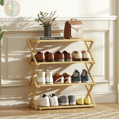 Étagère à chaussures en bambou à 4 niveaux. Un support pliable en bois clair avec structure en X, présentant quatre étagères remplies de chaussures sous un sac et un vase décoratif.