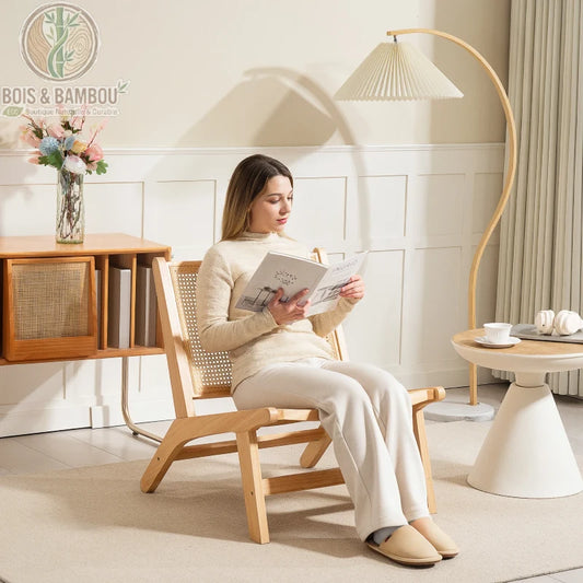 Fauteuil en Rotin et Bois d'Hévéa : siège bas au design scandinave avec dossier en rotin tressé et structure robuste en bois clair. Parfait pour un coin lecture zen et élégant.