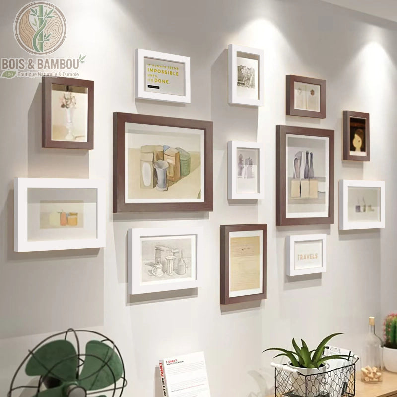 Galerie Murale en Bois Massif Héritage, une composition de douze cadres photo alternant le bois sombre et le blanc pur, mettant en valeur des croquis et des citations inspirantes dans un agencement moderne sur un mur clair.