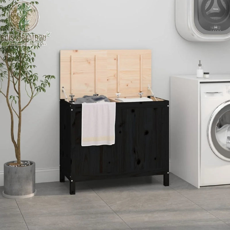 Grand panier a linge en bois de pin massif double noir. Coffre à linge double en bois noir avec couvercle ouvert révélant deux compartiments, installé dans une buanderie moderne avec machine à laver.