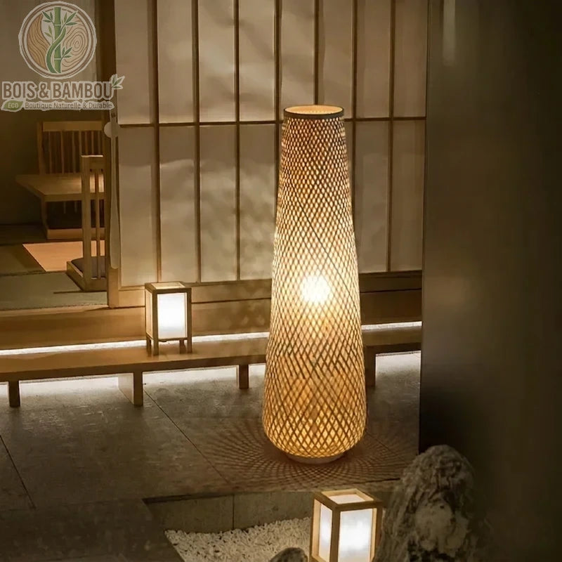Lampadaire en bambou et osier au design élancé et fuselé, mariant artisanat traditionnel et esthétique contemporaine.