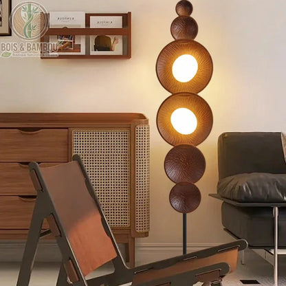 Lampadaire bois massif style sabi dans salon avec buffet rotin ambiance lumière chaude
