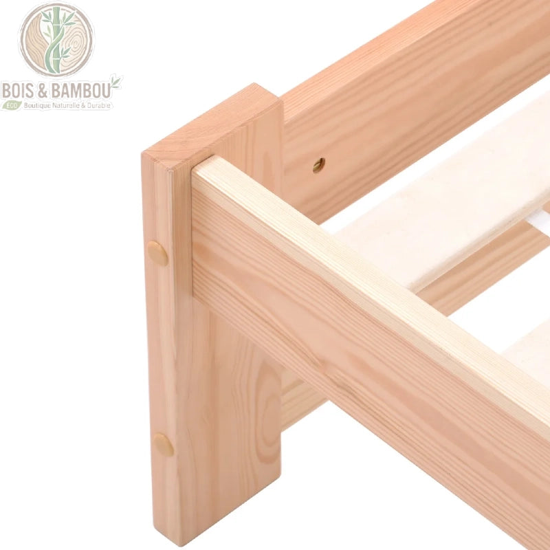 Lit Futon en Bois Massif descriptif. Gros plan sur l'assemblage et la finition d'un angle de cadre de lit en bois de pin clair, montrant la structure robuste et les lattes du sommier.