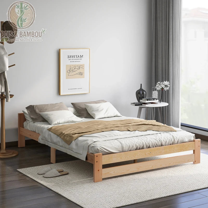 Lit Tatami en Bois de Pin. Un cadre de lit bas et minimaliste en bois clair, sans tête de lit, agrémenté de literie blanche et beige dans une chambre au style épuré.