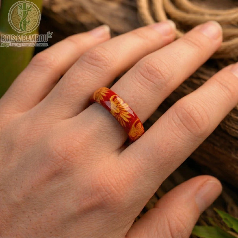 Lot de 10 bagues en bois vintage montrant une main portant l'une des dix bagues de la collection. La bague présentée est un anneau en bois fin et élégant , avec une finition laquée rouge vif.