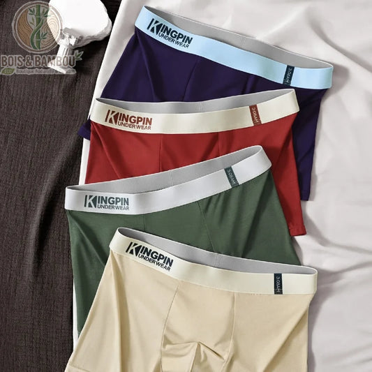 Lot de 4 boxers en fibre de bambou pour homme. Quatre boxers colorés (bleu marine, bordeaux, vert kaki, beige) de la marque Kingpin alignés sur un drap blanc. Textile doux et durable.
