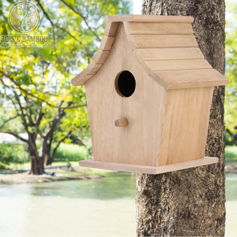 Maison d'élevage suspendue en bois de pin. Un nichoir classique en bois clair fixé au tronc d'un arbre, doté d'un trou d'entrée rond et d'un petit perchoir, au bord d'un plan d'eau.