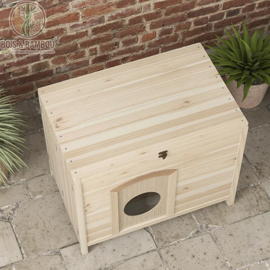 Maisonnette en Bois Massif. Une niche d'extérieur rectangulaire en bois clair avec une petite porte munie d'un hublot, installée sur une terrasse en pierre devant un mur en briques.