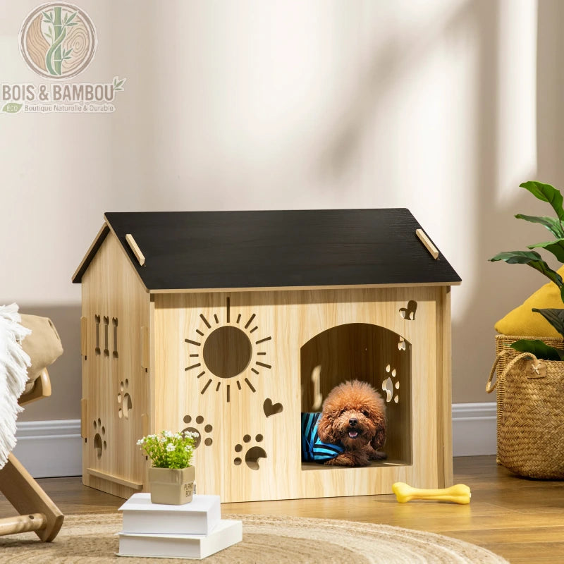 Maisonnette en Bois pour Chien. Une niche d'intérieur en bois clair avec un toit noir et des motifs de soleil et pattes découpés, abritant un petit chien brun dans un salon décoré.