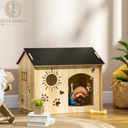 Maisonnette en Bois pour Chien. Une niche d'intérieur en bois clair avec un toit noir et des motifs de soleil et pattes découpés, abritant un petit chien brun dans un salon décoré.