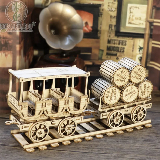 Maquette en bois Wagon à Vin. Une maquette détaillée en bois découpé représentant un wagon de passagers suivi d'un wagon chargé de tonneaux "Ale Brewery" sur des rails miniatures.