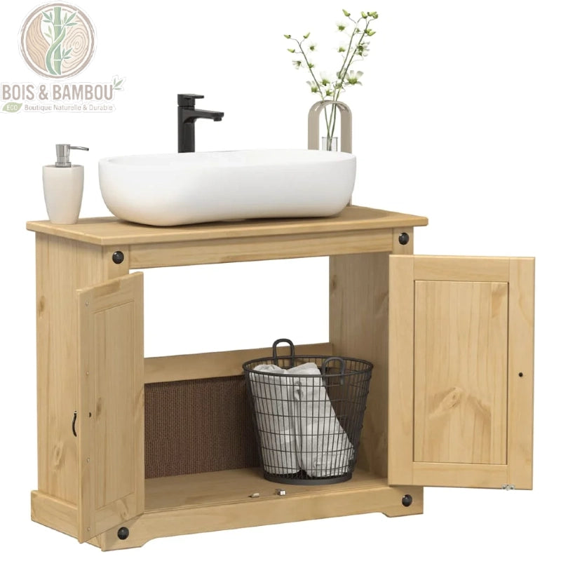 Meuble de Salle de Bain Corona ouvert. Meuble sous-vasque en pin clair avec portes ouvertes, révélant une étagère, un panier métallique de serviettes, une vasque ovale et un mitigeur noir.