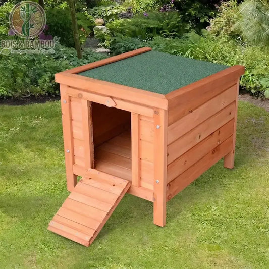 Niche pour chien en bois de sapin surélevée sur pieds, toit vert asphalté et rampe d'accès pliable dans un jardin