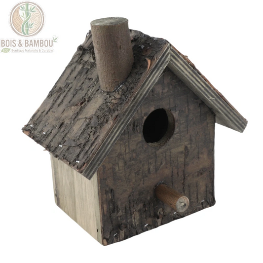 Nichoir à oiseaux suspendu en bois. Un petit nichoir rustique fabriqué en bois brut avec écorce, doté d'un toit à pignon, d'une petite cheminée décorative et d'un perchoir.
