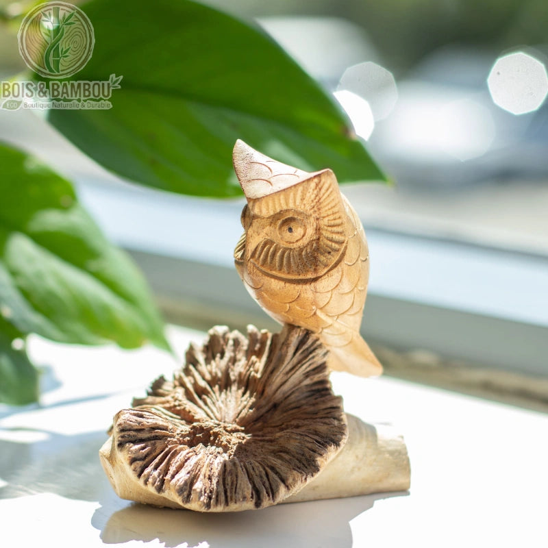 Sculpture chouette en bois posée sur un rebord de fenêtre
