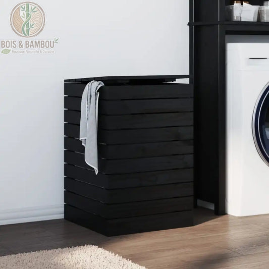 Panier a Linge en Pin Massif noir 44 44 66 cm. Coffre à linge design en bois de pin noir avec structure à claire-voie et couvercle, installé dans une buanderie moderne à côté d'un lave-linge.