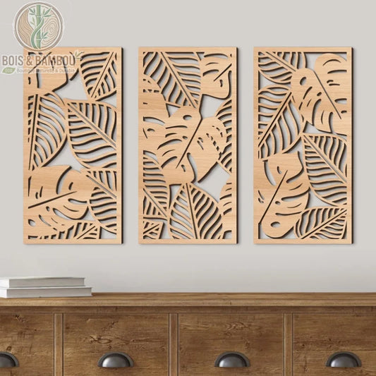 Panneau mural ajouré en bois avec motifs de feuilles tropicales (Monstera). Triptyque décoratif de fabrication artisanale au style naturel.