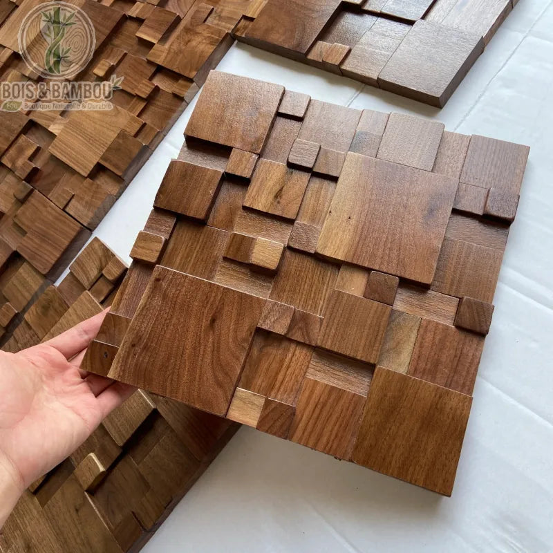 Panneau acoustique bois massif noyer foncé 30x30 cm tenu à la main