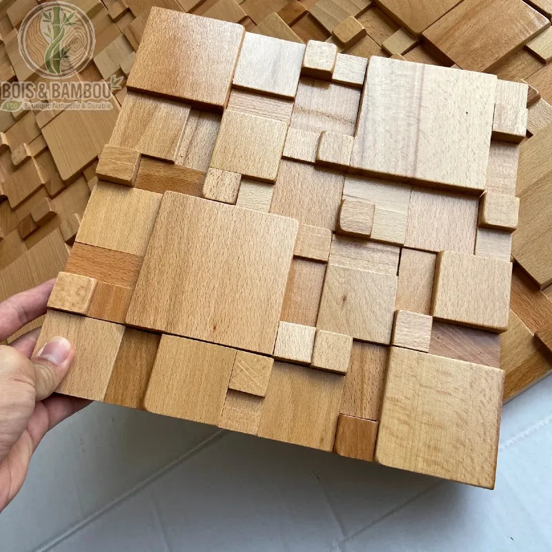 Panneau mural bois massif hêtre naturel clair relief 3D cubes tenu à la main
