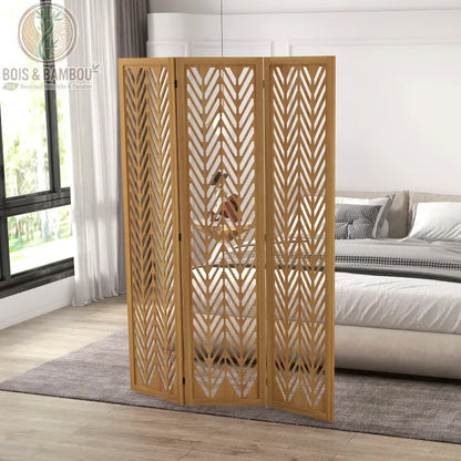 Paravent en Bois de Paulownia, une séparation de pièce à trois panneaux présentant un motif ajouré en chevrons élégant. L'image montre le paravent installé dans une chambre à coucher contemporaine, offrant une solution esthétique pour créer de l'intimité tout en ajoutant une texture naturelle et chaleureuse à la décoration.