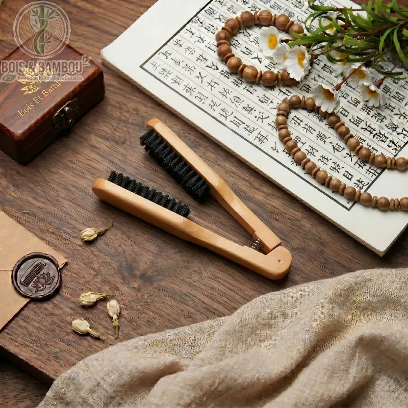 Peigne à cheveux à double tête en bois avec poils de sanglier. Brosse lissante à pince ergonomique sur table en bois avec décor zen. Accessoire de coiffage naturel et professionnel.