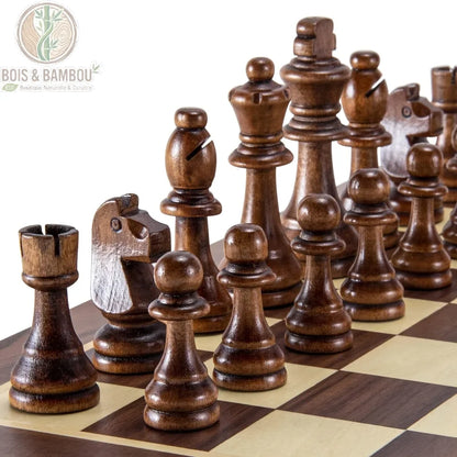 Pièces de jeu d'échecs en bois naturel. Gros plan sur un ensemble de pièces d'échecs en bois sombre sculpté, alignées sur un échiquier aux cases claires et foncées.