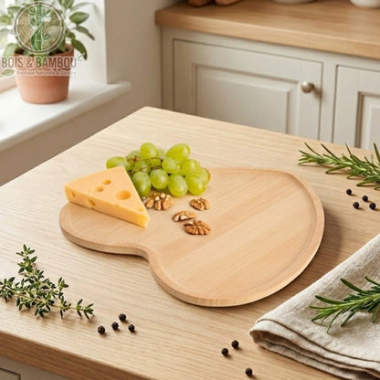 Plateau Cœur en Bambou 22 cm avec fromage et raisins, grains de poivre éparpillés, cuisine naturelle en arrière-plan, ambiance lumineuse et chaleureuse