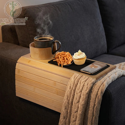 Plateau d accoudoir de canape en bambou 1. Plateau flexible en bambou épousant l'accoudoir d'un canapé, équipé d'un porte-gobelet avec café fumant, de snacks et d'un smartphone.