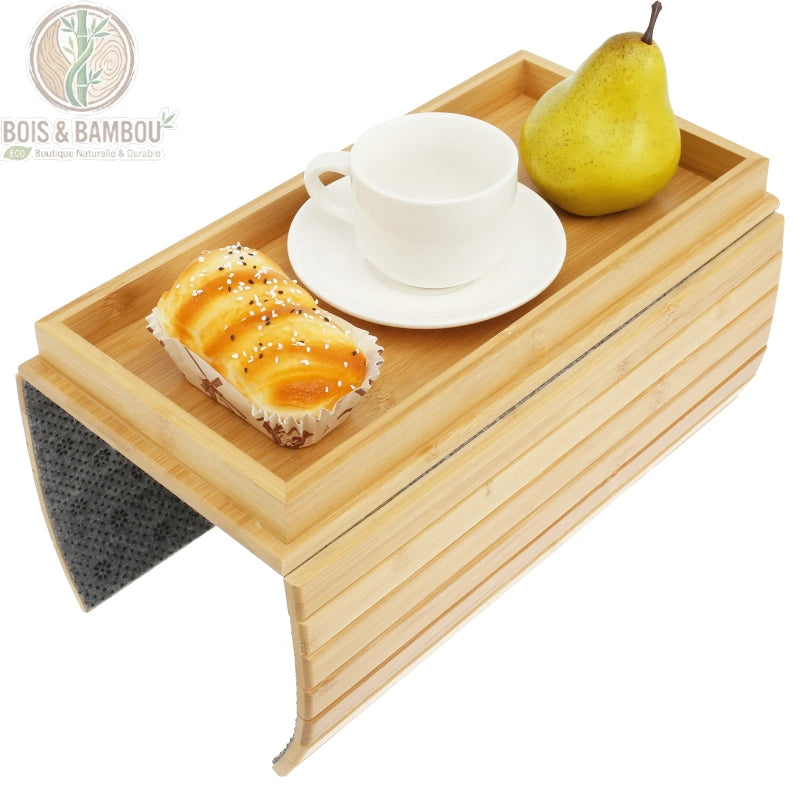 Plateau d accoudoir de canape en bambou 5. Un plateau flexible en bambou naturel avec bords surélevés, présentant une tasse blanche, une viennoiserie et une poire, sur un fond blanc épuré.