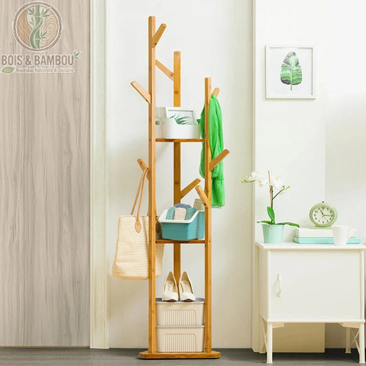 Porte Manteau sur Pied en Bambou situation 2. Support d'angle multifonctionnel en bambou avec étagères et nombreux crochets, organisé avec sacs, chaussures et accessoires dans une entrée lumineuse.
