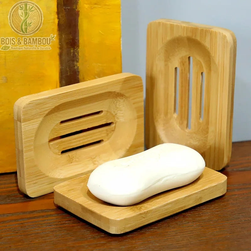 Porte-Savon en Bambou Rectangulaire. Trois porte-savons dont un avec un pain de savon blanc sur un plan de travail en bois. Design épuré et naturel.