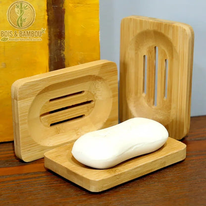 Porte-Savon en Bambou Rectangulaire. Trois porte-savons dont un avec un pain de savon blanc sur un plan de travail en bois. Design épuré et naturel.