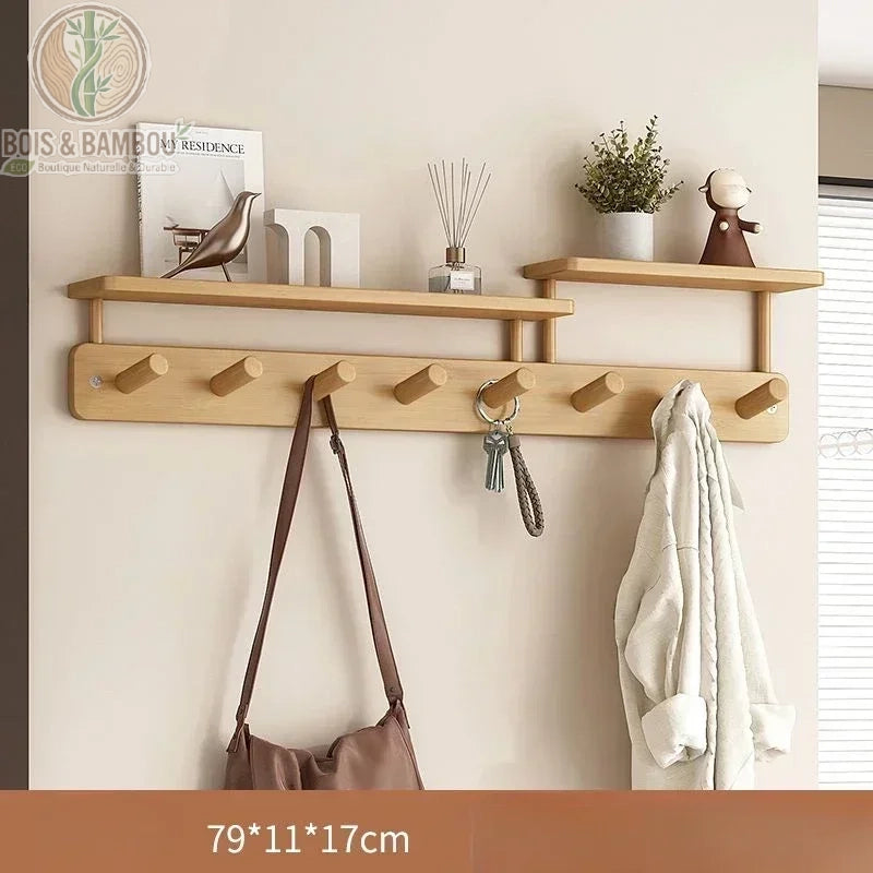 Porte manteau mural créatif en bambou dimension 79 11 17 claire : grande étagère en bois clair avec sept crochets, un sac et une veste, agrémentée d'objets de décoration zen et d'une petite plante.
