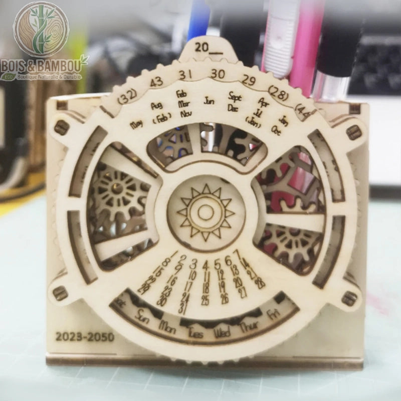 Porte-stylo calendrier perpétuel en bois. Un accessoire de bureau en bois découpé au laser avec un mécanisme d'engrenages rotatifs pour les dates, servant également de pot à crayons.