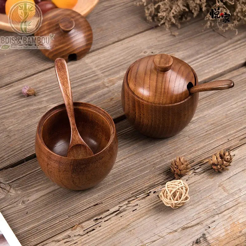 Pot à épices rétro en bois de jujubier avec couvercle. Deux pots à épices en bois riche, l'un ouvert avec sa cuillère à l'intérieur, l'autre fermé avec sa cuillère en place, sur une table rustique.