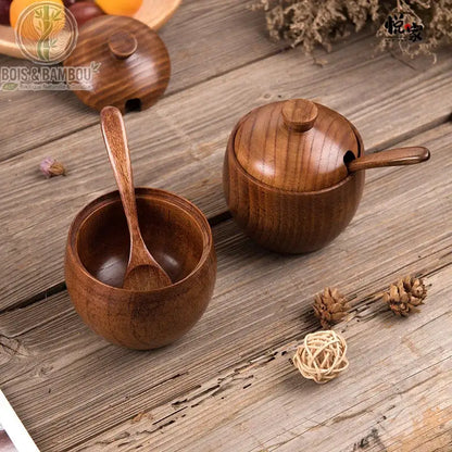 Pot à épices rétro en bois de jujubier avec couvercle. Deux pots à épices en bois riche, l'un ouvert avec sa cuillère à l'intérieur, l'autre fermé avec sa cuillère en place, sur une table rustique.