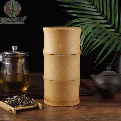 Pot de conservation en bambou naturel au design cylindrique à trois sections, évoquant la structure d'une tige de bambou. Idéal pour conserver le thé ou les herbes, ce récipient esthétique s'intègre parfaitement dans une décoration zen aux côtés d'accessoires de service à thé traditionnels.