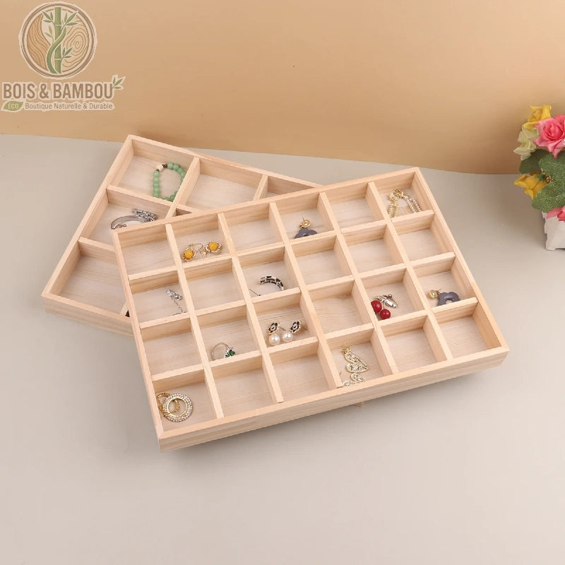 Présentoir à bijoux en bois naturel composé de plusieurs compartiments carrés pour organiser bagues et boucles d'oreilles. Fabrication artisanale au design minimaliste pour une présentation soignée.