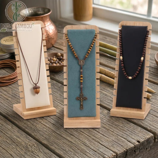 Présentoir à Collier Créatif en bambou avec supports colorés exposant des pendentifs et un chapelet sur un établi en bois rustique.