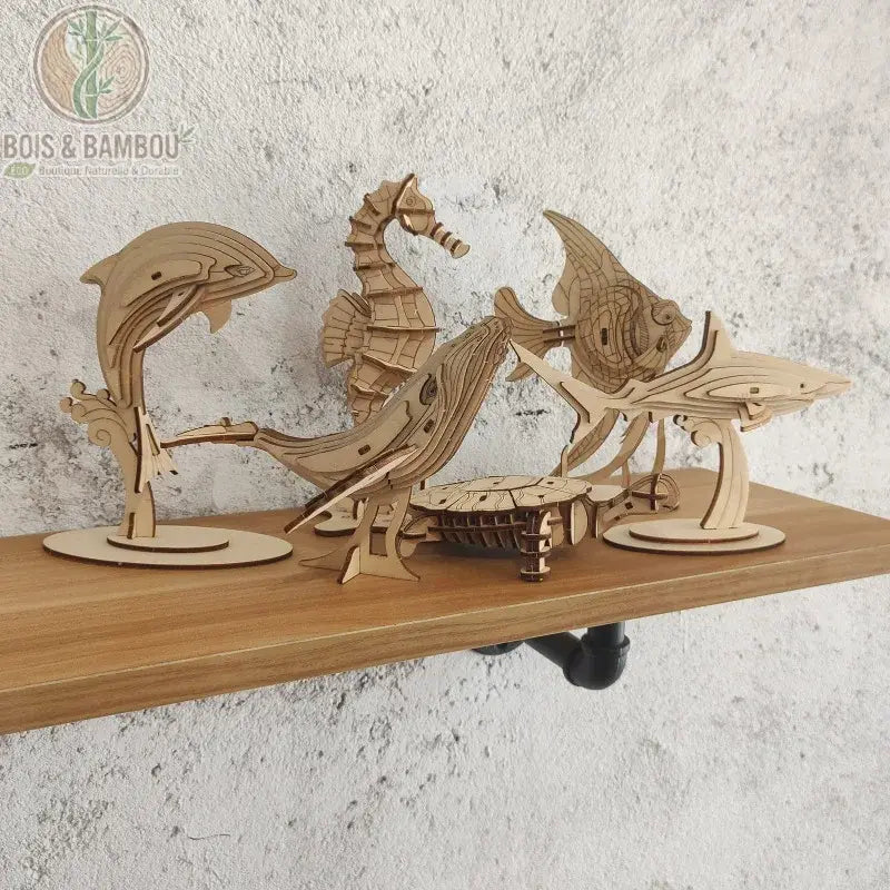 Puzzle 3D en bois Marine Life. Un ensemble de maquettes d'animaux marins à assembler incluant un dauphin, une baleine, un hippocampe, un requin et une tortue, exposés sur une étagère.