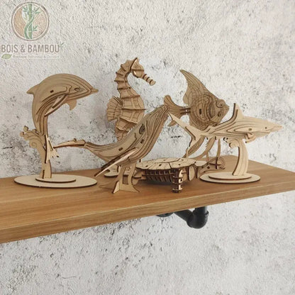 Puzzle 3D en bois Marine Life. Un ensemble de maquettes d'animaux marins à assembler incluant un dauphin, une baleine, un hippocampe, un requin et une tortue, exposés sur une étagère.
