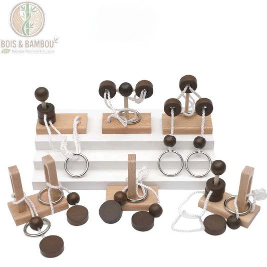 Puzzle casse-tête en corde et en bois. Ensemble de jeux de réflexion artisanaux en bois clair et foncé avec anneaux métalliques et cordes blanches sur un présentoir à marches.