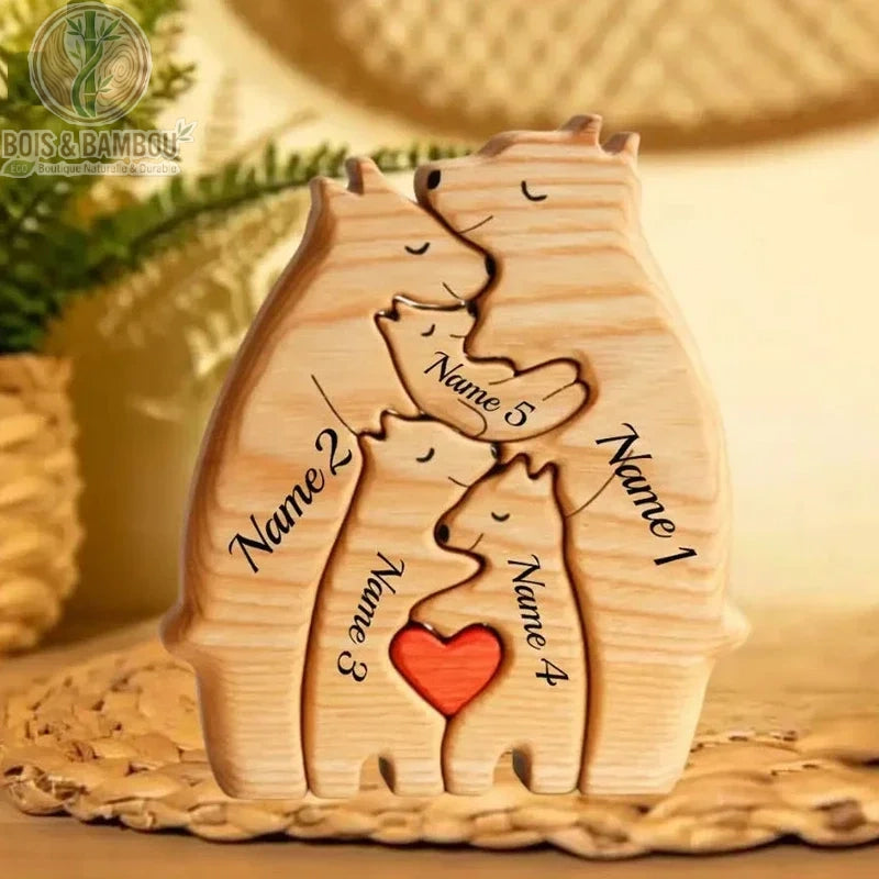 Puzzle familial ours en bois massif. Une figurine sculptée représentant une famille d'ours imbriqués avec des prénoms gravés et un petit cœur rouge au centre, sur un support tressé.