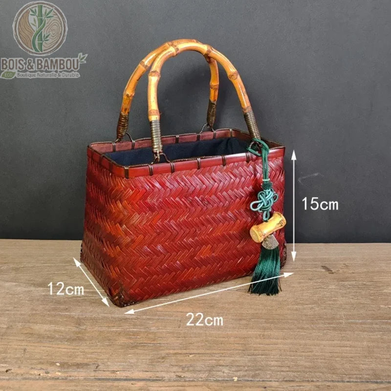 Sac cabas Coffret en bambou rouge dimensions. Infographie d'un sac en bambou rouge tressé de 22 cm de long, 12 cm de large et 15 cm de haut, avec anses en bambou et pompon décoratif vert.